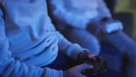 Close-Up-Of-Two-Young-Boys-At-Home-Playing-With-Computer-Games-Console-On-TV-Holding-Controllers-Late-At-Night-11